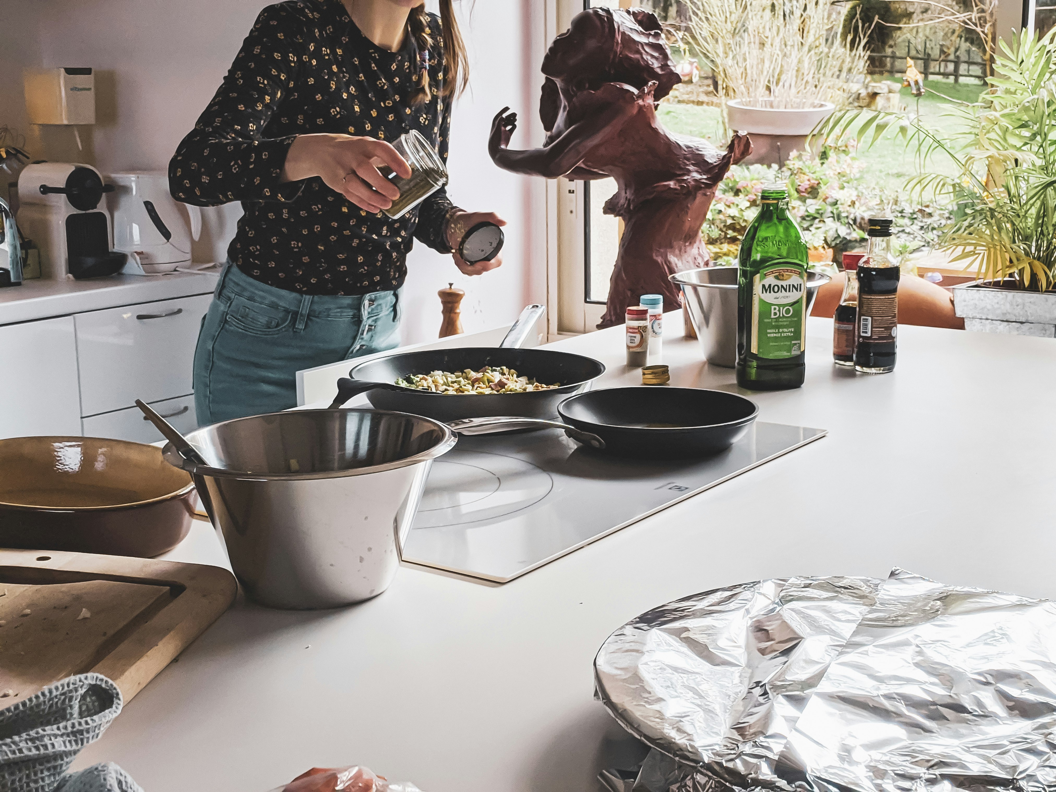 woman in black and white polka dot shirt holding stainless steel cooking pot